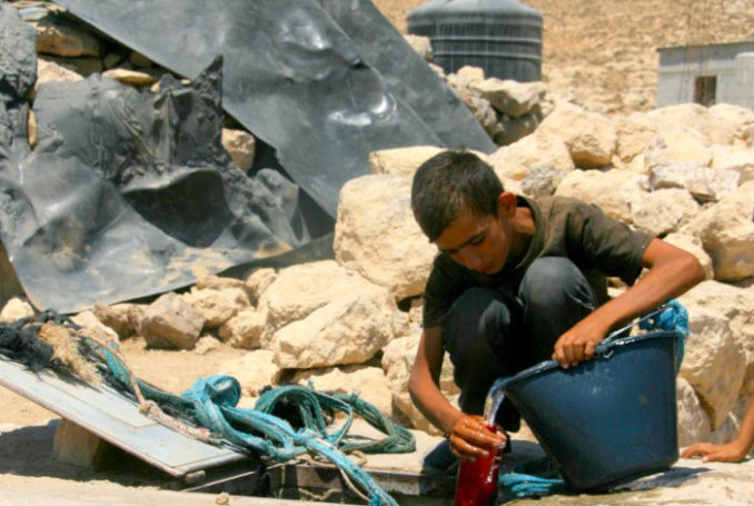 L’apartheid de l’eau en Palestine - Août 2012 - Un jeune garçon tire de l'eau d'un puits, dans le village de Khirbet Jebdah - au sud des collines d'Hébron - qui n'est relié à aucun réseau de distribution d'eau - Photo : B'TSelem